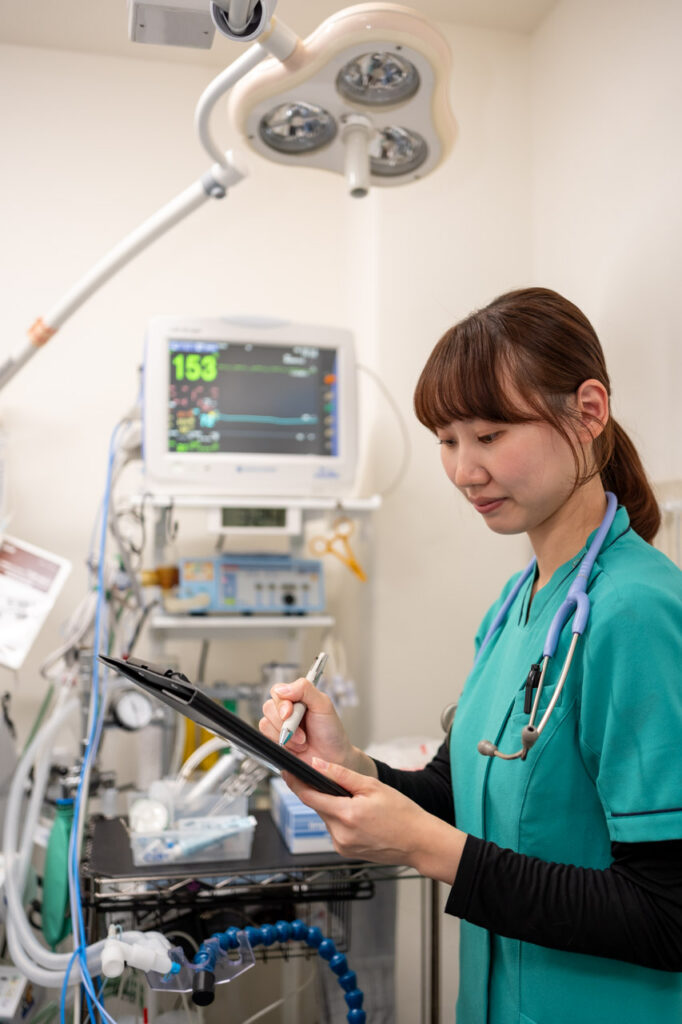 手術室で記録をとる動物看護師